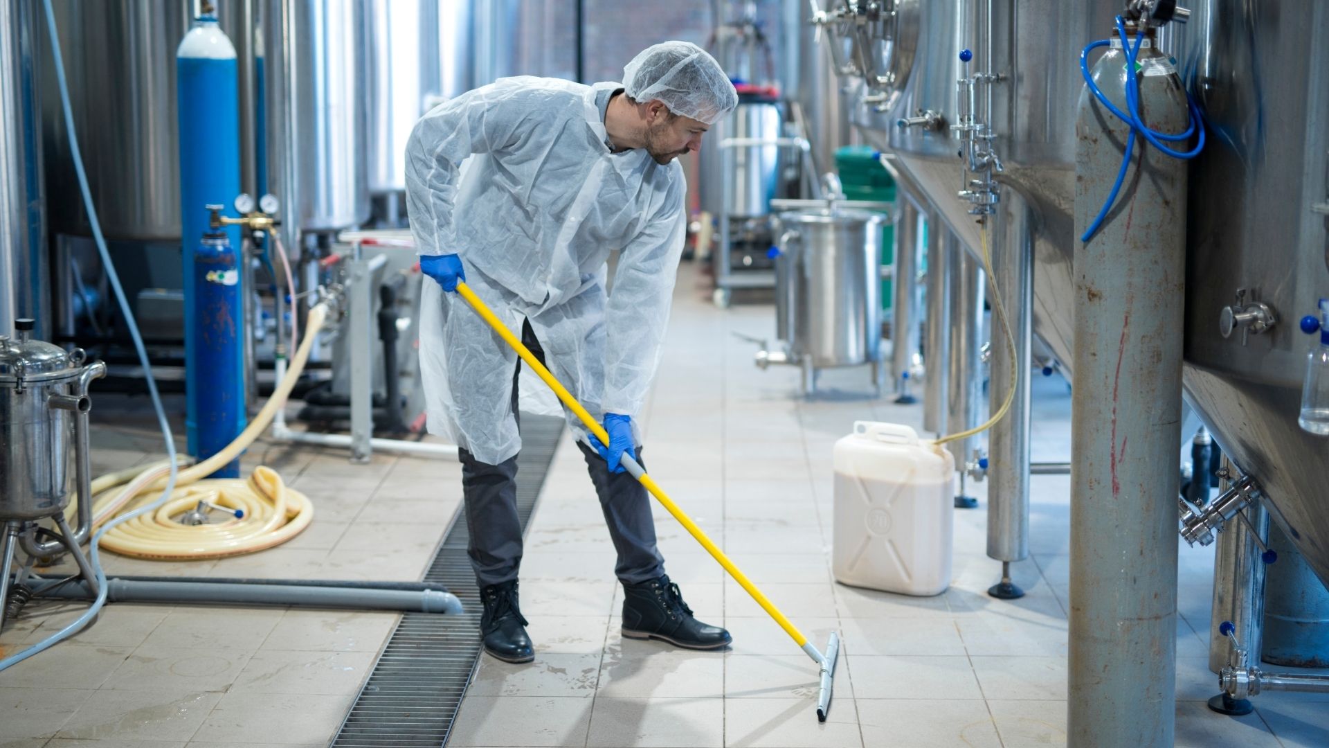 man cleaning the floor in a brewery