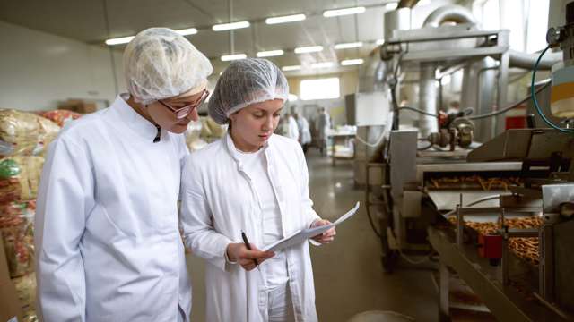 Women checking documents at meat processing plant