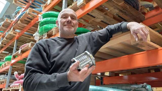 Man in warehouse with a sight glass in his hand